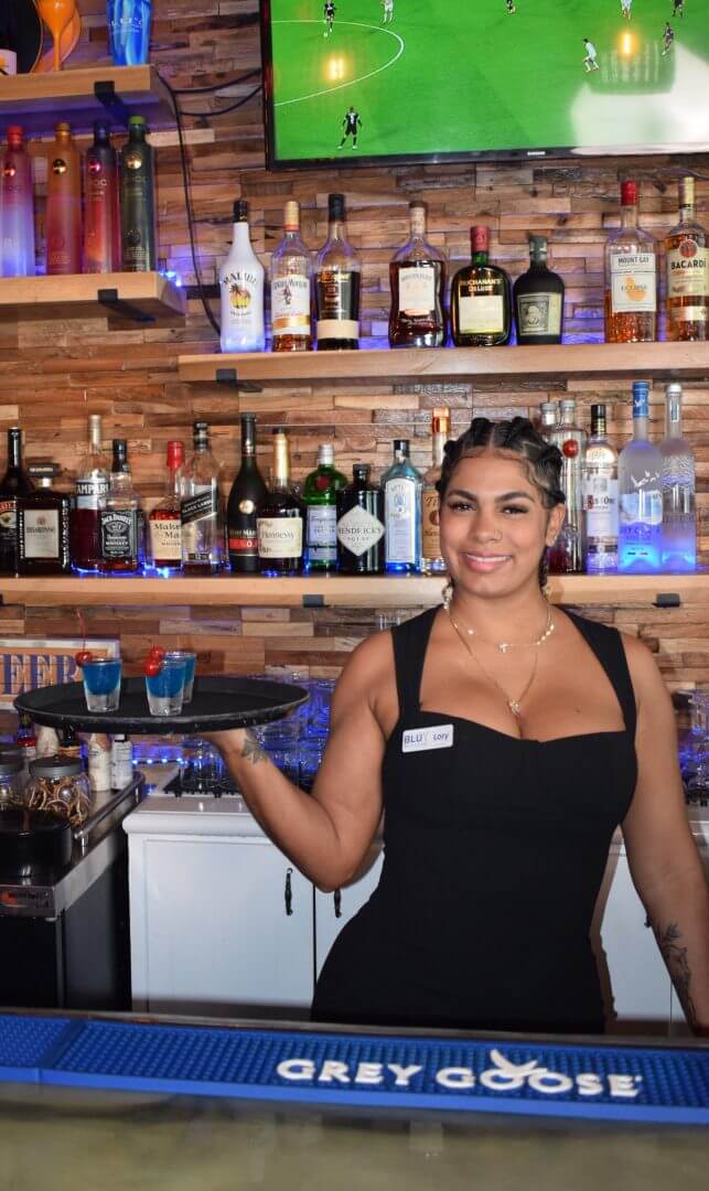 Server holding drinks at the bar